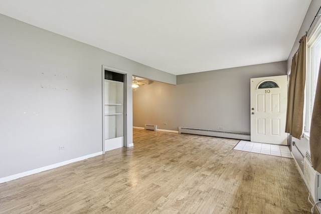 241 Northway Park Rd Unit 10, Machesney Park, IL 61115 - empty room with a baseboard heating unit, light wood-type flooring, ceiling fan, baseboards, and a baseboard radiator