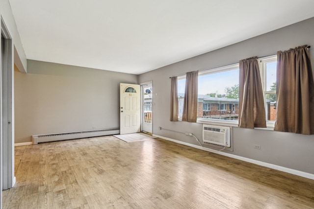 241 Northway Park Rd Unit 10, Machesney Park, IL 61115 - unfurnished room with a baseboard radiator, an AC wall unit, wood finished floors, and baseboards
