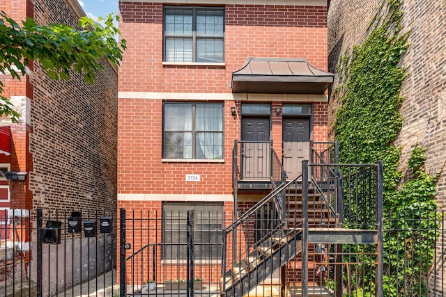 3134 S Morgan St, Chicago, IL 60608 - view of front of house featuring brick siding, a fenced front yard, and a gate