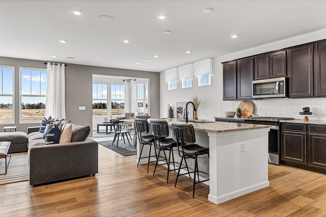 24708 W Owen Ct, Plainfield, IL 60585 - kitchen featuring stainless steel appliances, a sink, open floor plan, an island with sink, and a breakfast bar area
