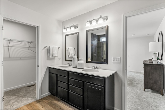 24708 W Owen Ct, Plainfield, IL 60585 - full bath featuring double vanity, a walk in closet, wood finished floors, and baseboards