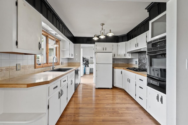35632 N Sheridan Dr, Fox Lake, IL 60020 - kitchen with black appliances, a warming drawer, under cabinet range hood, and white cabinetry