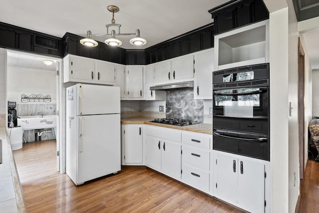 35632 N Sheridan Dr, Fox Lake, IL 60020 - kitchen with black appliances, a warming drawer, light countertops, light wood finished floors, and under cabinet range hood