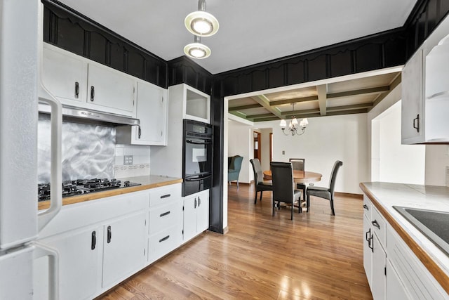 35632 N Sheridan Dr, Fox Lake, IL 60020 - kitchen featuring black appliances, a warming drawer, under cabinet range hood, a chandelier, and light wood-type flooring