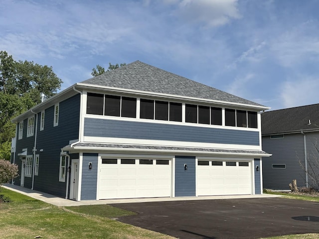 571 Mill St Unit 2, Fontana, WI 53125 - view of property exterior featuring an attached garage, driveway, and roof with shingles