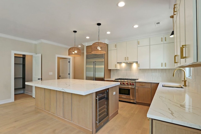 571 Mill St Unit 2, Fontana, WI 53125 - kitchen featuring high quality appliances, wine cooler, a sink, a kitchen island, and light wood-style flooring