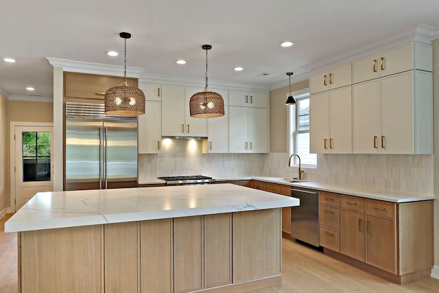 571 Mill St Unit 2, Fontana, WI 53125 - kitchen featuring appliances with stainless steel finishes, a center island, a sink, light wood-style flooring, and light stone countertops