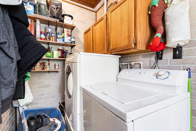 431 Montrose Dr, Romeoville, IL 60446 - laundry area featuring washer and clothes dryer, cabinet space, and brick wall