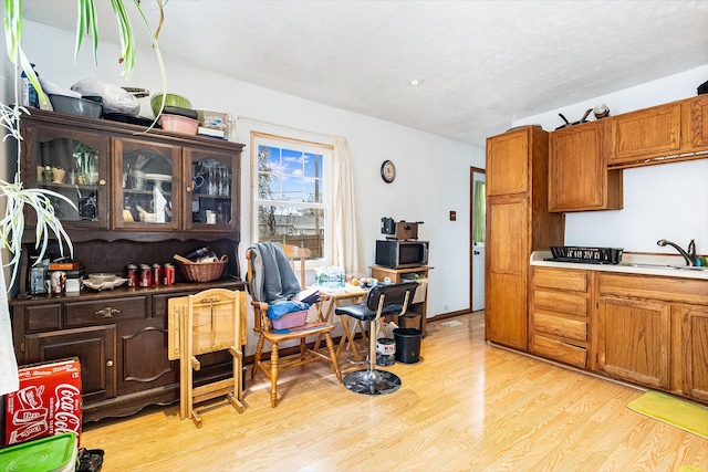 431 Montrose Dr, Romeoville, IL 60446 - kitchen with a sink, stainless steel microwave, light wood finished floors, glass insert cabinets, and recessed lighting