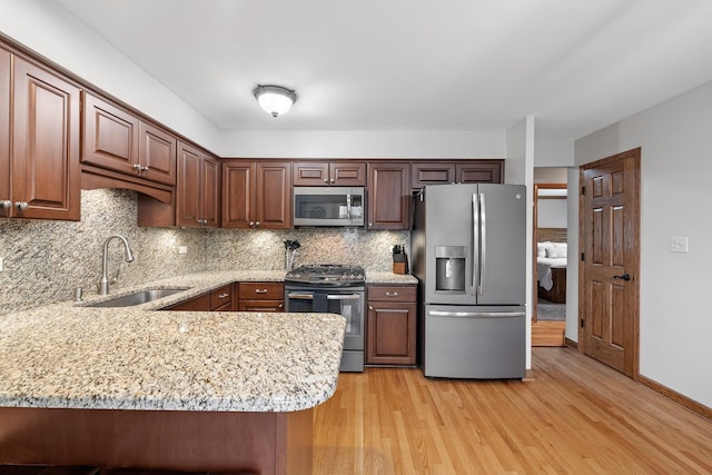 13641 W Ironwood Cir, Homer Glen, IL 60491 - kitchen featuring stainless steel appliances, a sink, decorative backsplash, light wood-type flooring, and a peninsula