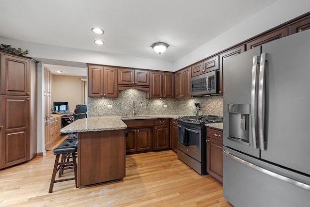 13641 W Ironwood Cir, Homer Glen, IL 60491 - kitchen with stainless steel appliances, a breakfast bar, light wood finished floors, tasteful backsplash, and recessed lighting