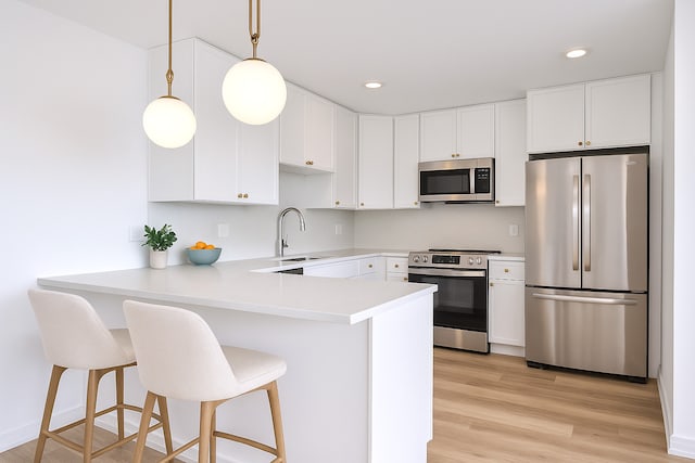 9396 Landings Ln Unit 305, Des Plaines, IL 60016 - kitchen with stainless steel appliances, a sink, a peninsula, light countertops, and white cabinets