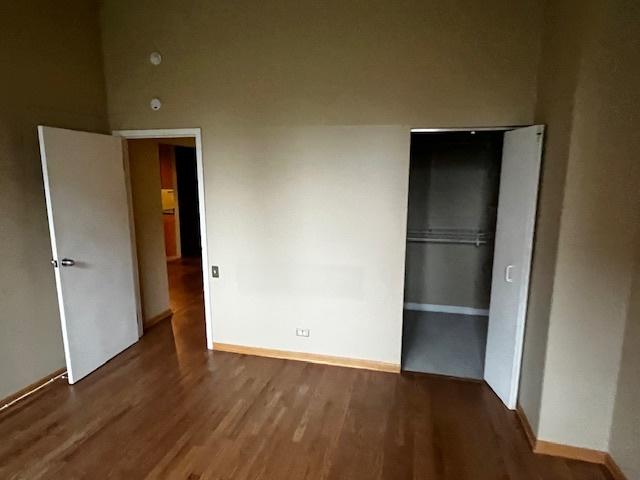 600 S Dearborn St Unit 308, Chicago, IL 60605 - unfurnished bedroom with wood finished floors, baseboards, and a closet