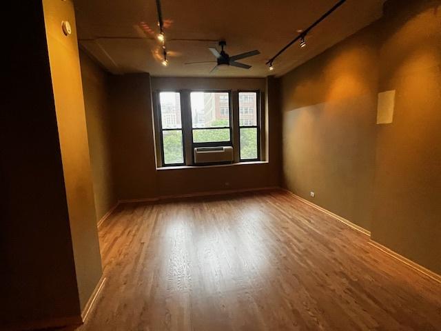 600 S Dearborn St Unit 308, Chicago, IL 60605 - unfurnished room with rail lighting, wood finished floors, and baseboards