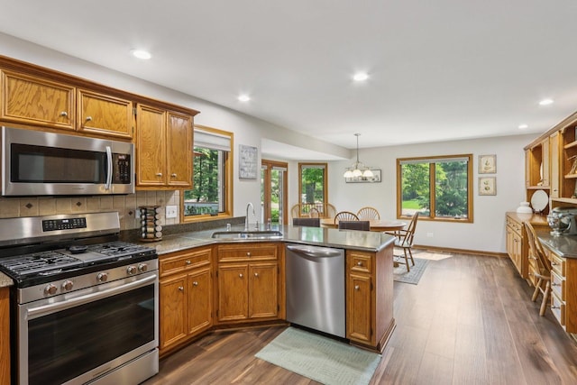 11624 Kluth Ct, Mokena, IL 60448 - kitchen with stainless steel appliances, a peninsula, brown cabinets, dark wood-style floors, and recessed lighting