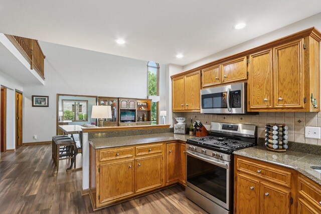 11624 Kluth Ct, Mokena, IL 60448 - kitchen with stainless steel appliances, brown cabinets, tasteful backsplash, a peninsula, and recessed lighting