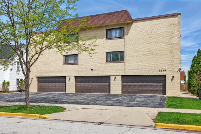 1258 Brown St Unit 204, Des Plaines, IL 60016 - view of building exterior with an attached garage and asphalt driveway