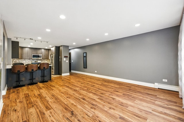 1258 Brown St Unit 204, Des Plaines, IL 60016 - unfurnished living room with a baseboard heating unit, light wood-type flooring, recessed lighting, and track lighting