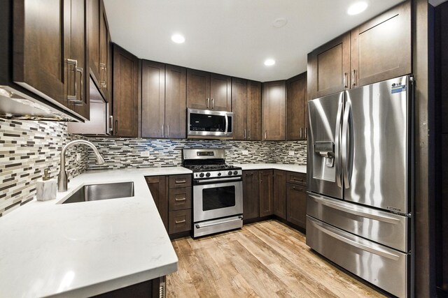 1258 Brown St Unit 204, Des Plaines, IL 60016 - kitchen with appliances with stainless steel finishes, dark brown cabinetry, light countertops, tasteful backsplash, and light wood-type flooring