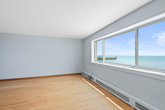 1050 W Columbia Ave Unit 3H, Chicago, IL 60626 - empty room with a baseboard heating unit, light wood finished floors, a water view, and baseboards