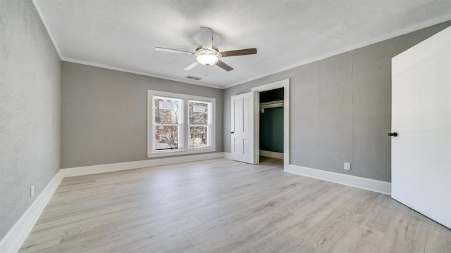 639 W Elk St, Freeport, IL 61032 - unfurnished bedroom with light wood-type flooring, crown molding, ceiling fan, baseboards, and a textured ceiling
