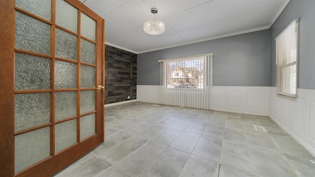 639 W Elk St, Freeport, IL 61032 - tiled spare room featuring crown molding and wainscoting