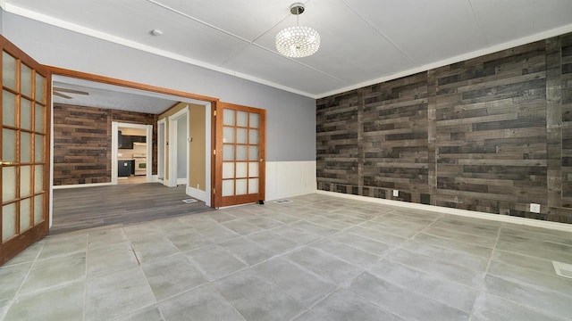 639 W Elk St, Freeport, IL 61032 - spare room featuring french doors and wood walls