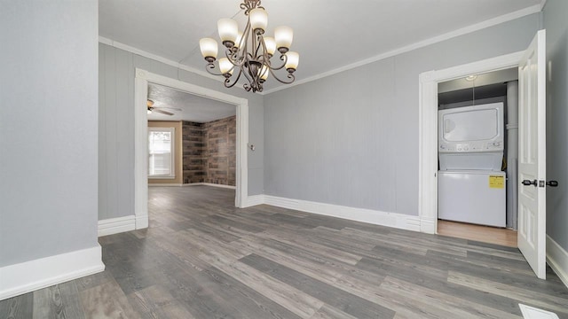 639 W Elk St, Freeport, IL 61032 - empty room with stacked washer / dryer, crown molding, wood finished floors, a chandelier, and baseboards
