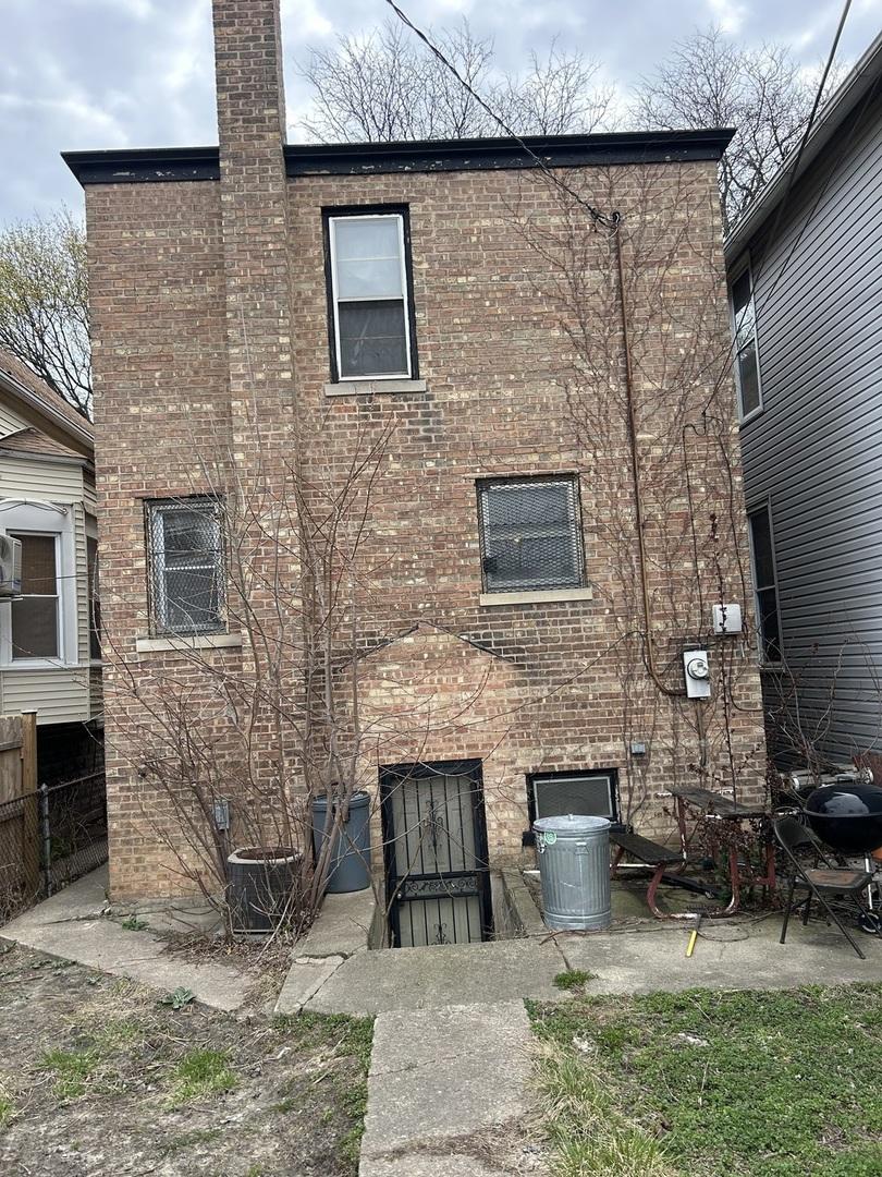 9438 S Champlain Ave, Chicago, IL 60619 - back of property featuring brick siding, central AC, and a chimney