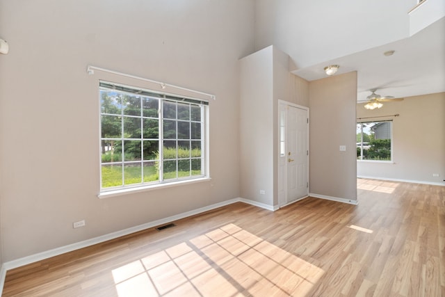 390 Jamestown Ct, Aurora, IL 60502 - entryway featuring a towering ceiling, baseboards, a ceiling fan, and light wood-type flooring