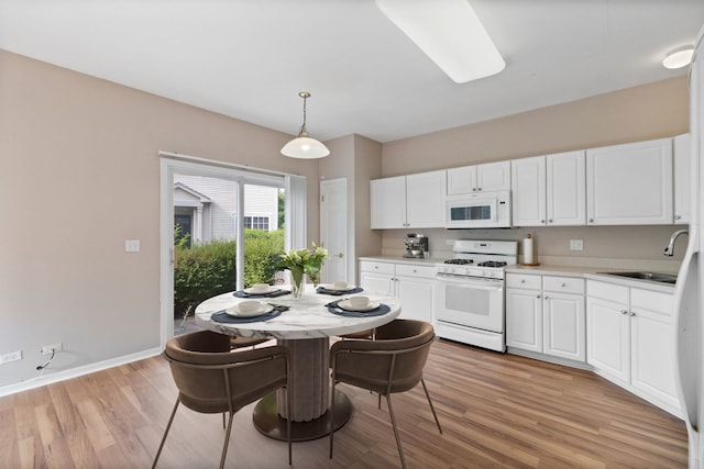 390 Jamestown Ct, Aurora, IL 60502 - kitchen featuring white appliances, a sink, light wood-style floors, white cabinets, and pendant lighting