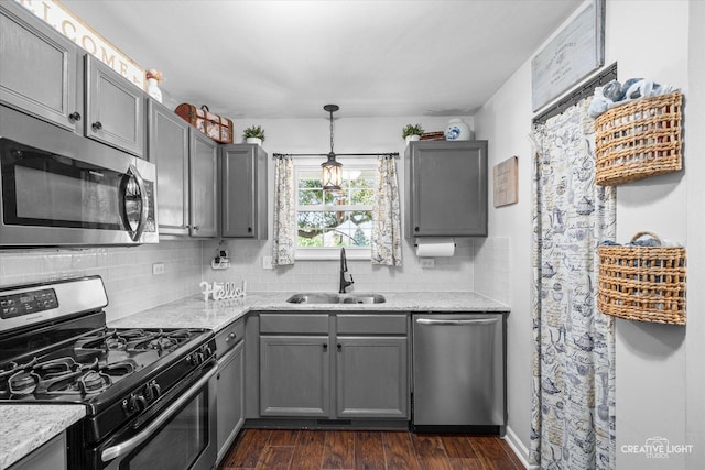28 Waterbury Cir, Oswego, IL 60543 - kitchen featuring appliances with stainless steel finishes, gray cabinetry, backsplash, and dark wood-style flooring