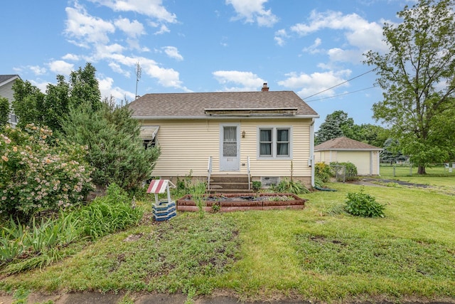 424 Robinson St, Earlville, IL 60518 - view of front of house with a front lawn, a chimney, a detached garage, and a shingled roof