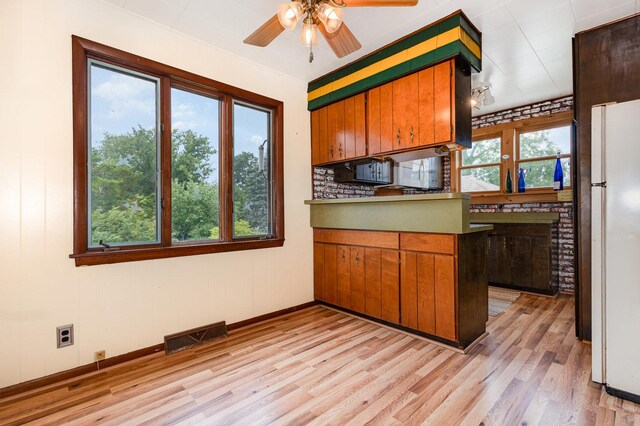 424 Robinson St, Earlville, IL 60518 - kitchen featuring freestanding refrigerator, light wood-type flooring, ceiling fan, and brown cabinets