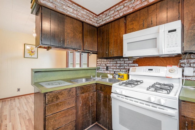 424 Robinson St, Earlville, IL 60518 - kitchen featuring white appliances, light wood-style flooring, a peninsula, baseboards, and a sink