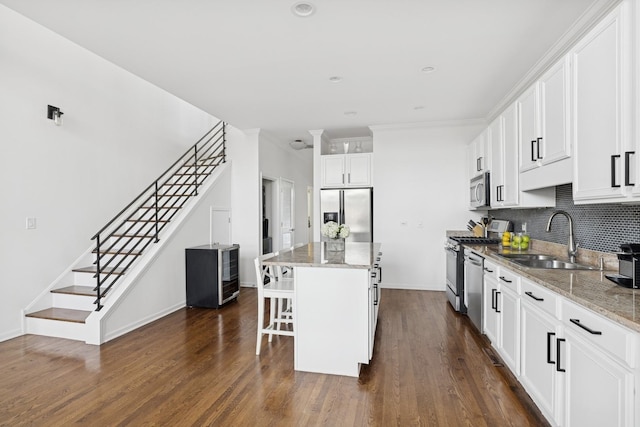 1632 W Erie St Unit 3, Chicago, IL 60622 - kitchen with stainless steel appliances, a breakfast bar, backsplash, a kitchen island, and light stone countertops
