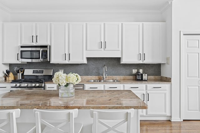 1632 W Erie St Unit 3, Chicago, IL 60622 - kitchen featuring appliances with stainless steel finishes, a kitchen bar, white cabinets, and ornamental molding
