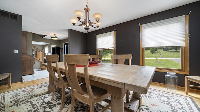 3894 E Whippoorwill Ln, Byron, IL 61010 - dining area with a chandelier, light wood-style flooring, baseboards, and stairway