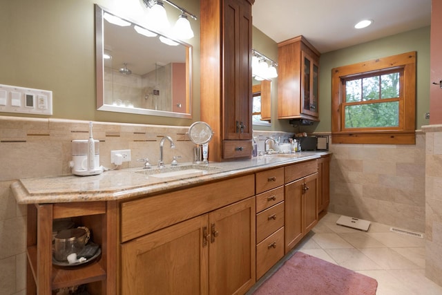 10415 Ridge Ln, Huntley, IL 60142 - bathroom featuring tile walls, double vanity, tile patterned floors, tiled shower, and wainscoting