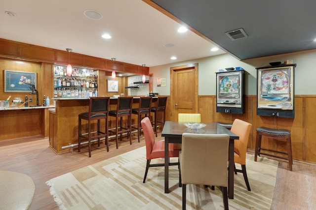 10415 Ridge Ln, Huntley, IL 60142 - dining area with wet bar, light wood finished floors, a wainscoted wall, wooden walls, and recessed lighting