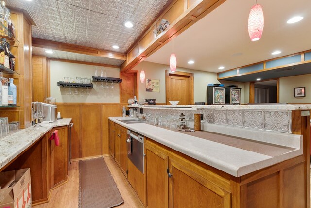 10415 Ridge Ln, Huntley, IL 60142 - kitchen with brown cabinetry, stainless steel dishwasher, light countertops, a peninsula, and light wood-style floors