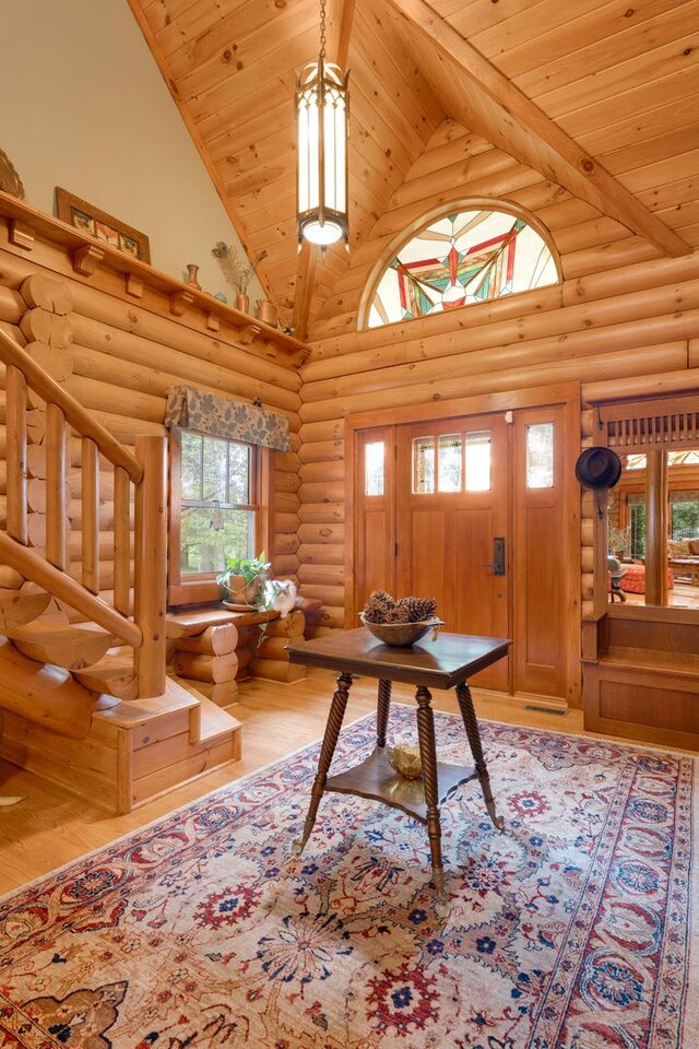 10415 Ridge Ln, Huntley, IL 60142 - entryway featuring log walls, high vaulted ceiling, wooden ceiling with exposed beams, wood finished floors, and stairs