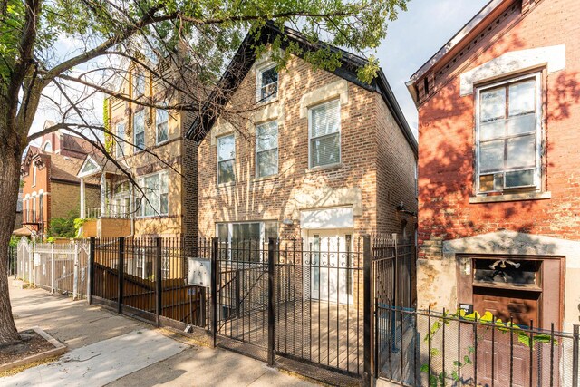 1407 N Bosworth Ave, Chicago, IL 60642 - view of front of house with brick siding, a fenced front yard, and a gate