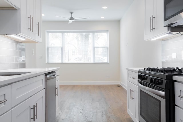 1407 N Bosworth Ave, Chicago, IL 60642 - kitchen with stainless steel appliances, ceiling fan, white cabinets, light wood-style floors, and recessed lighting