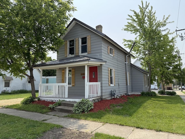 302 E Carroll St, Lanark, IL 61046 - view of front of house with covered porch, a chimney, a front yard, and metal roof