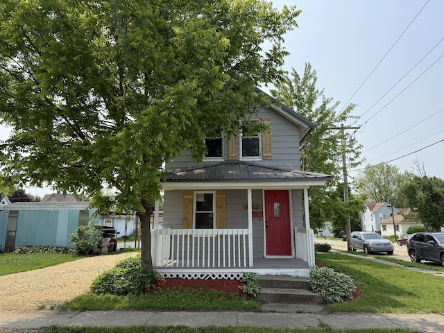 302 E Carroll St, Lanark, IL 61046 - view of front of property featuring covered porch, metal roof, a standing seam roof, and a front yard