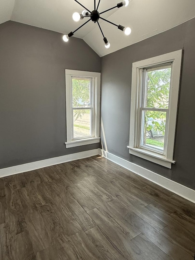 302 E Carroll St, Lanark, IL 61046 - unfurnished room featuring a chandelier, lofted ceiling, plenty of natural light, dark wood-type flooring, and baseboards
