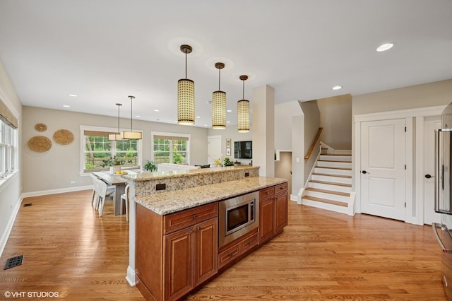 234 E Saint Charles Rd, Elmhurst, IL 60126 - kitchen with stainless steel microwave, brown cabinets, light wood finished floors, decorative light fixtures, and recessed lighting