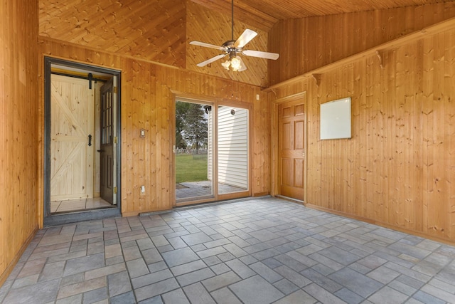 510 S Sycamore St, Genoa, IL 60135 - spare room featuring wooden walls, lofted ceiling, a ceiling fan, a barn door, and baseboards