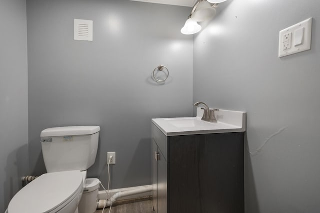 510 S Sycamore St, Genoa, IL 60135 - half bath with vanity, toilet, wood finished floors, and baseboards